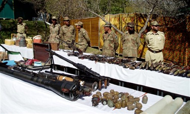 Pakistan army soldiers stand near confiscated arms and ammunition during operations against militants in Kalaya in Pakistan's tribal area of Orakzai near the Afghanistan border on Tuesday, Oct. 26.